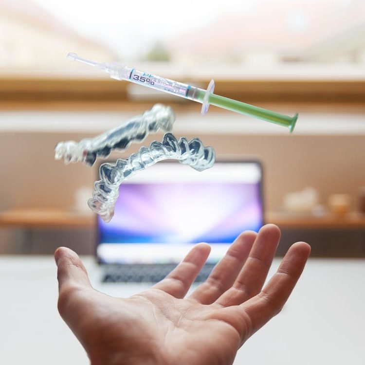 Clear dental aligners and a whitening-gel syringe