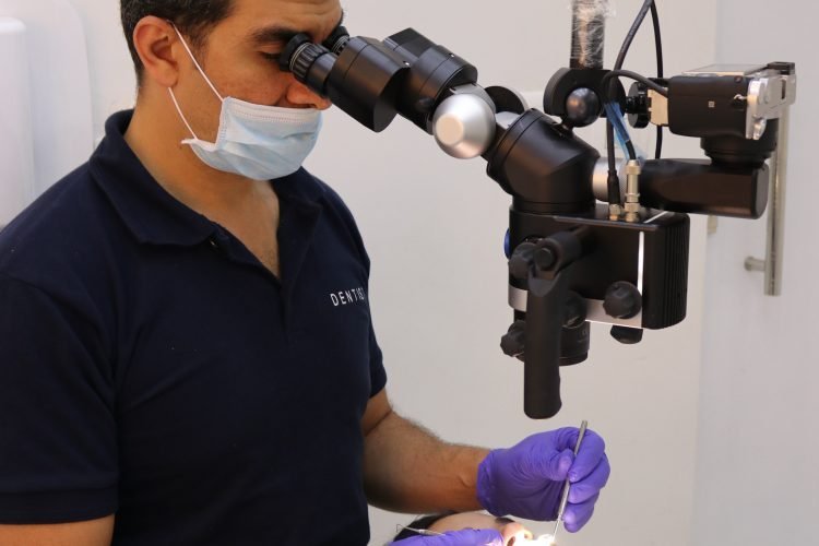 Dentist using a surgical microscope during treatment
