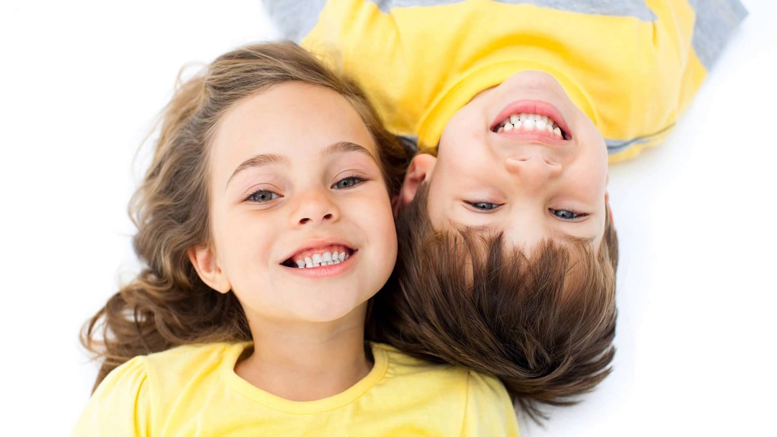 Two smiling children showing their teeth